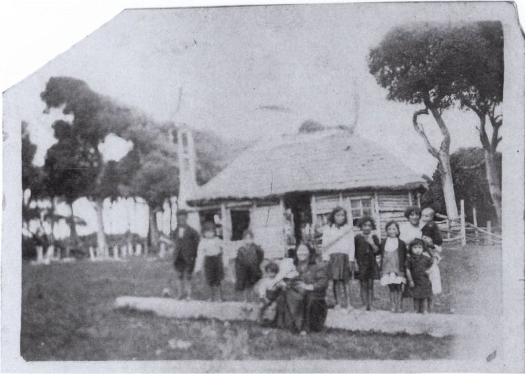 Local children and teacher in front of school.